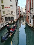 Famosa gondola veneziana con turisti che ammirano l'ambiente che stanno visitando